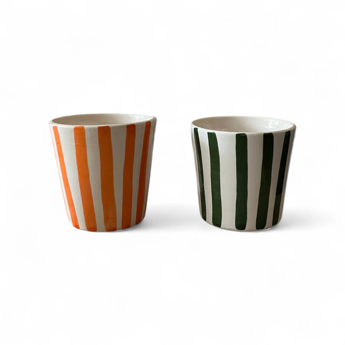 Two ceramic cups with striped patterns on a white background