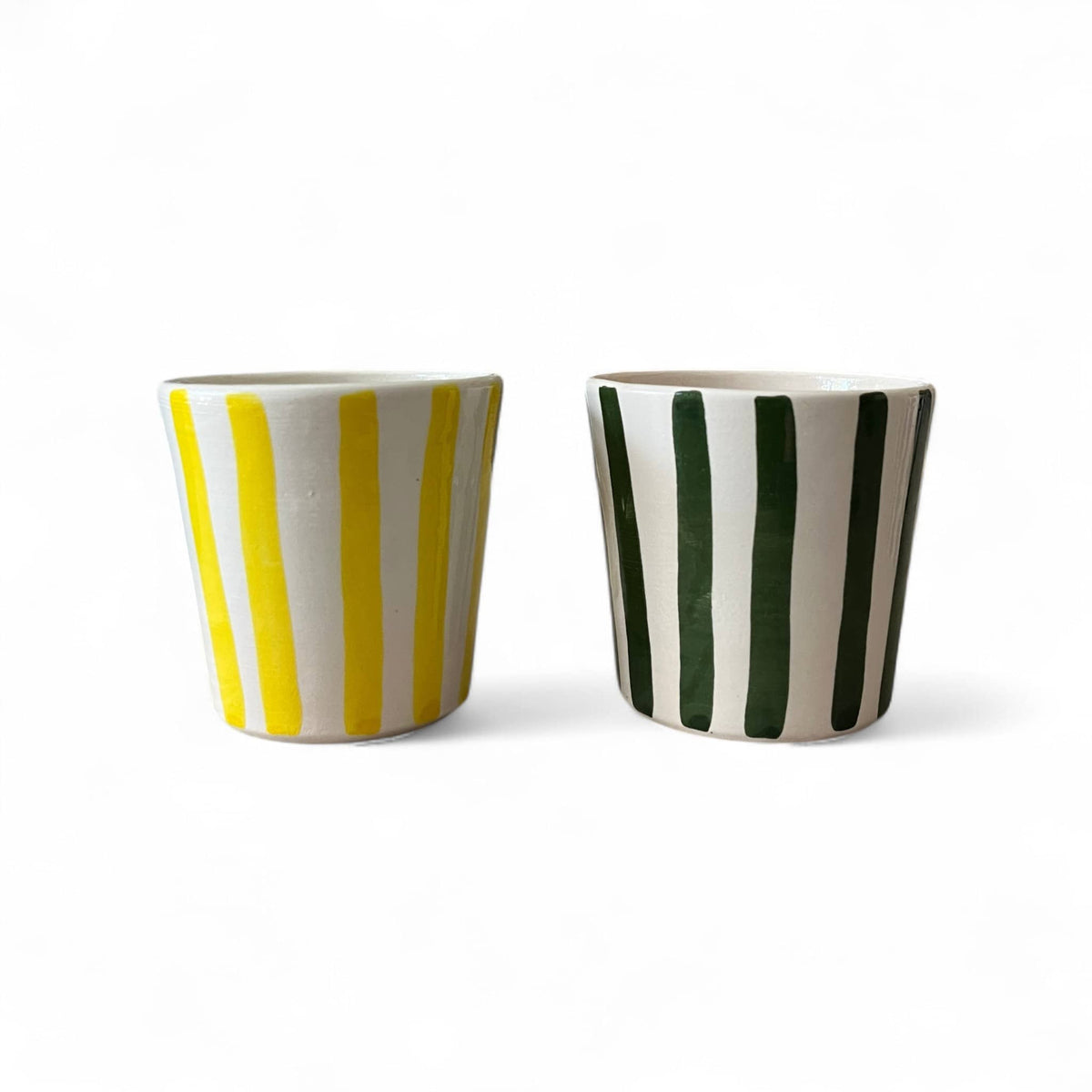 Two ceramic cups with striped patterns on a white background