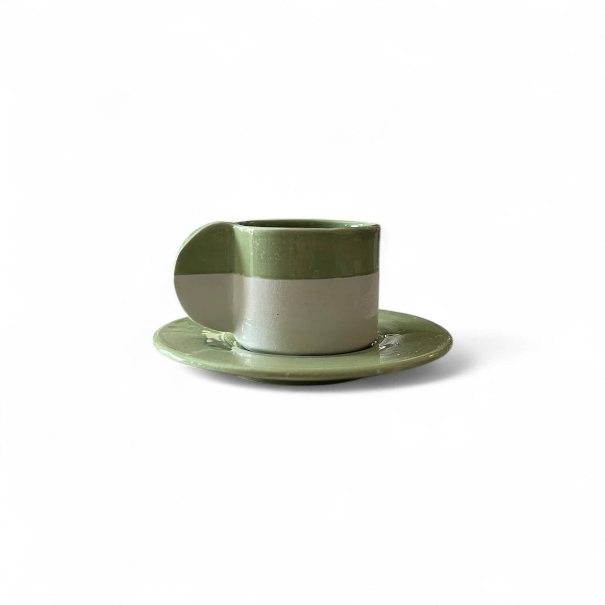 Green ceramic cup and saucer on a white background