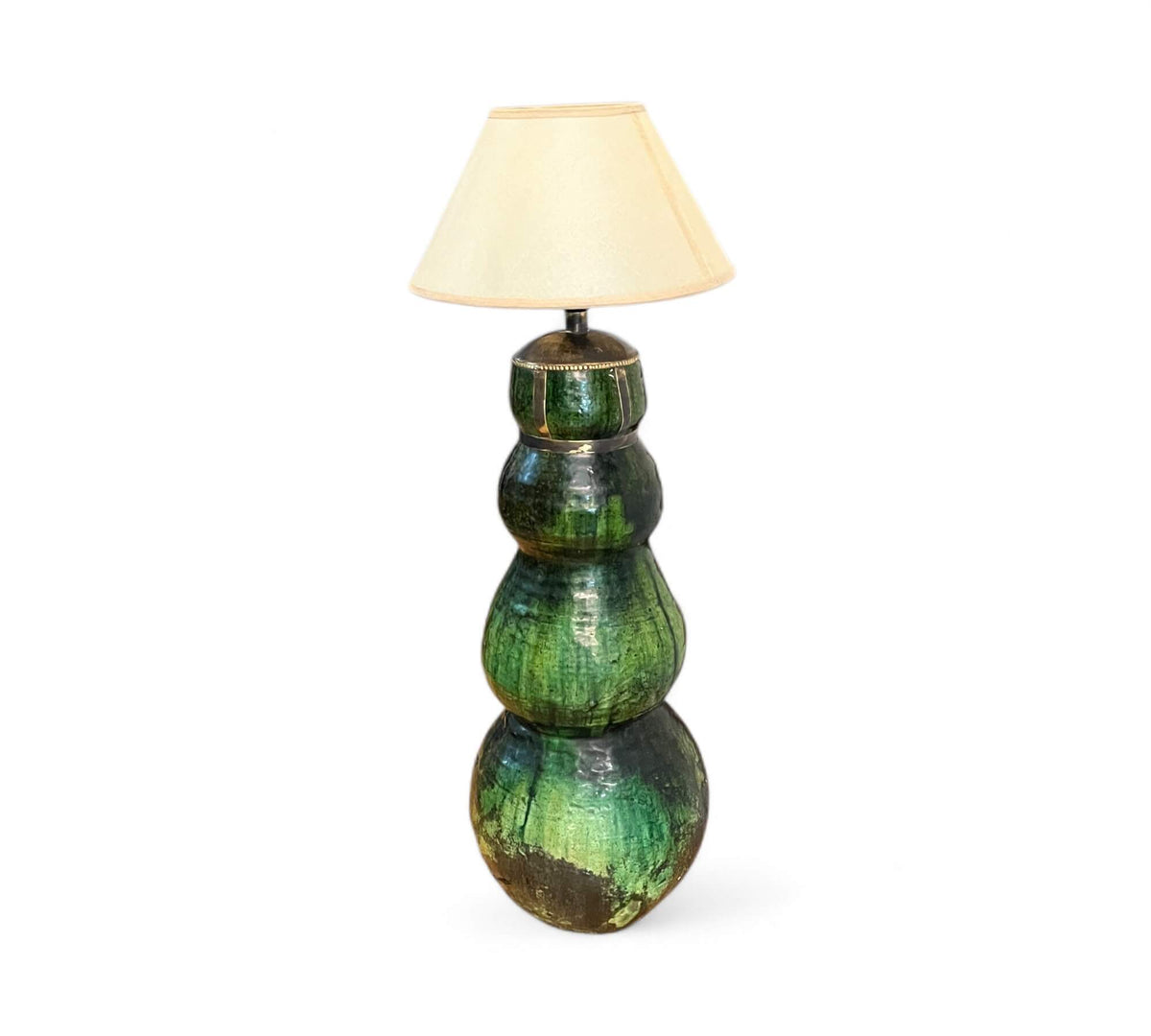 Green ceramic floor lamp with a beige lampshade on a white background