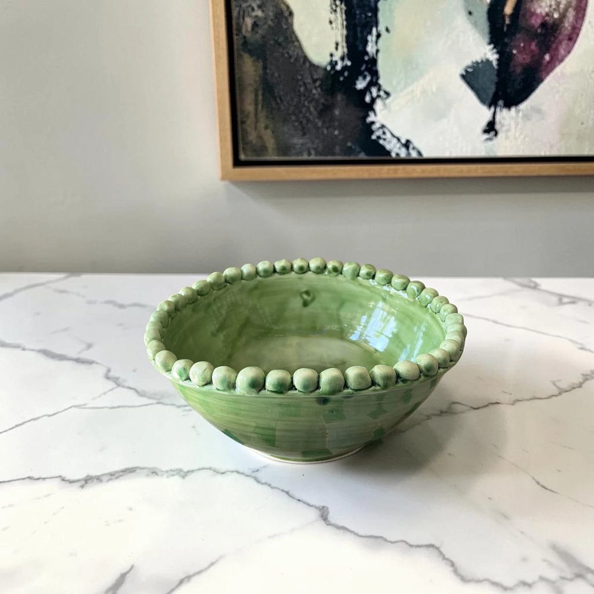 Handmade green ceramic serving bowl with beaded rim and artisan glaze