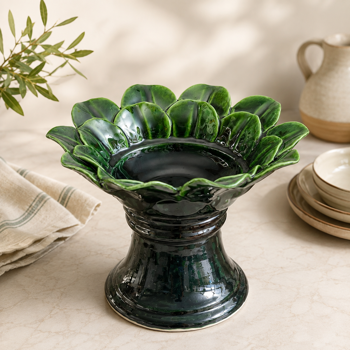 Handmade green ceramic pedestal bowl with flower-inspired design and elevated base