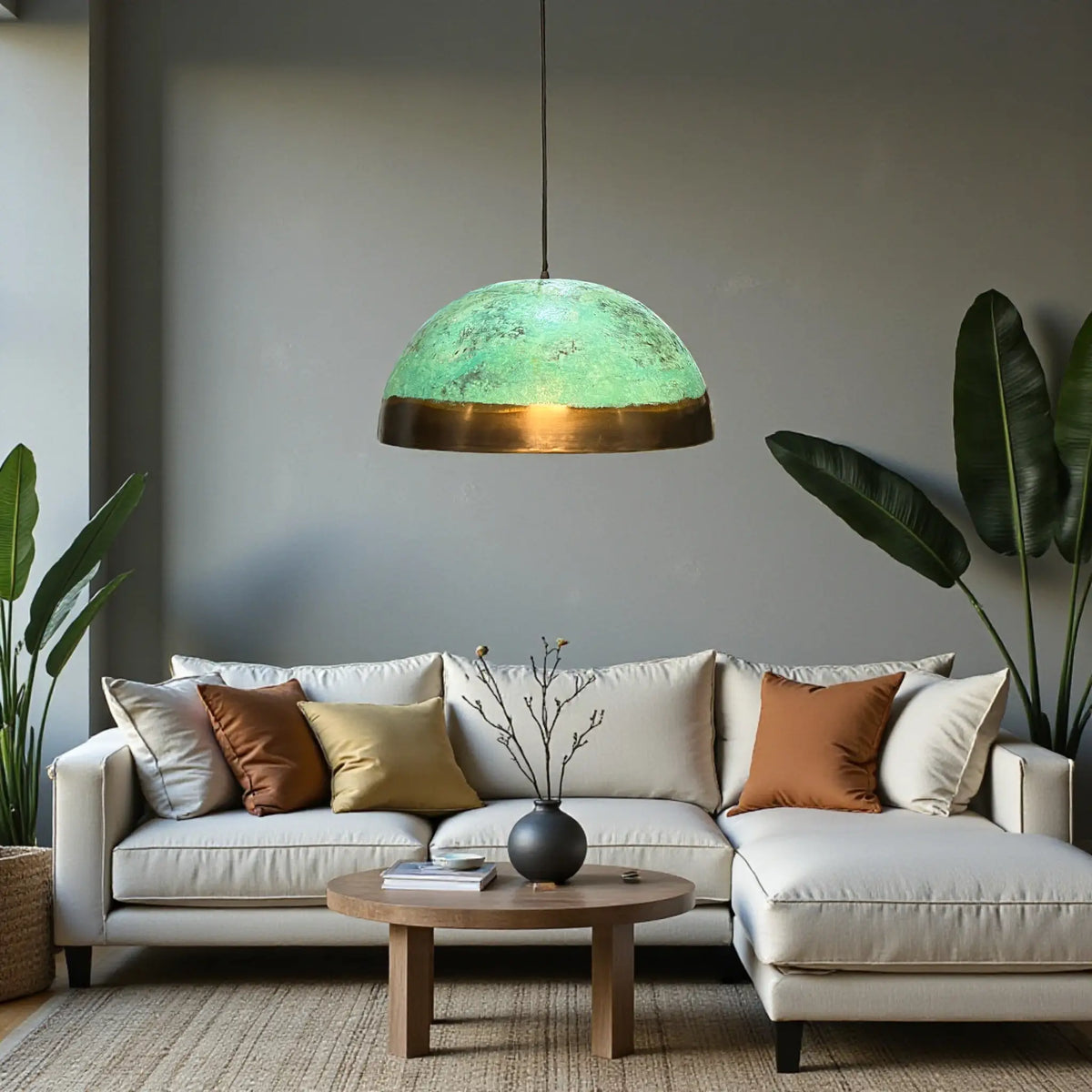 Handmade oxidized copper Moroccan pendant light with green patina and brass base hanging in modern living room
