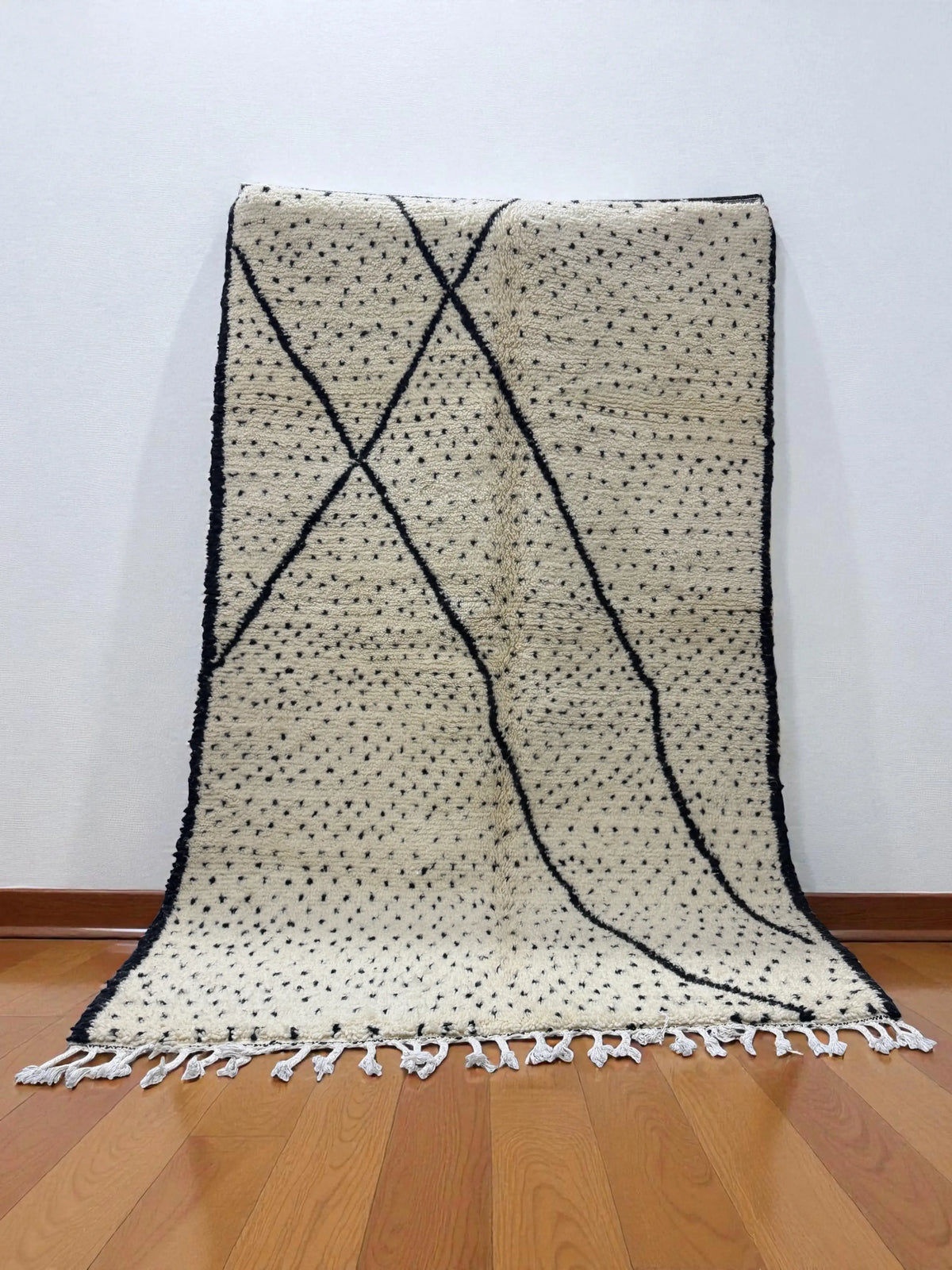 Handwoven Moroccan Azilal carpet in ivory wool with black dotted and linear patterns, 252 × 158 cm