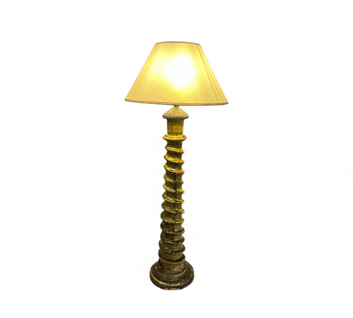 Decorative floor lamp with a textured base and beige shade on a white background