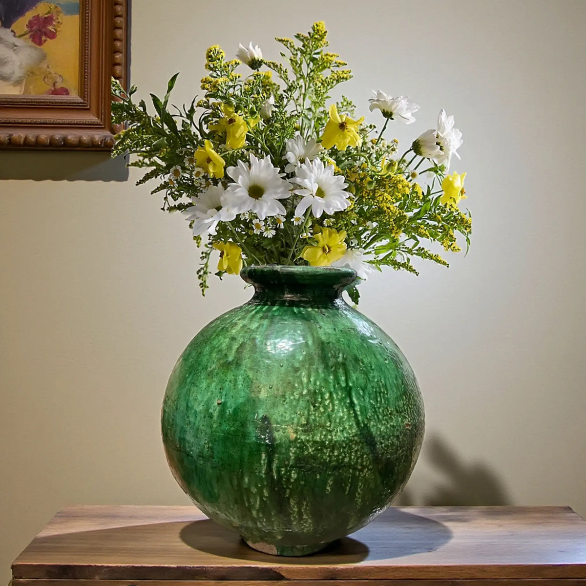 Large rounded handmade Tamegroute pottery vase with deep green kiln glaze on wooden table