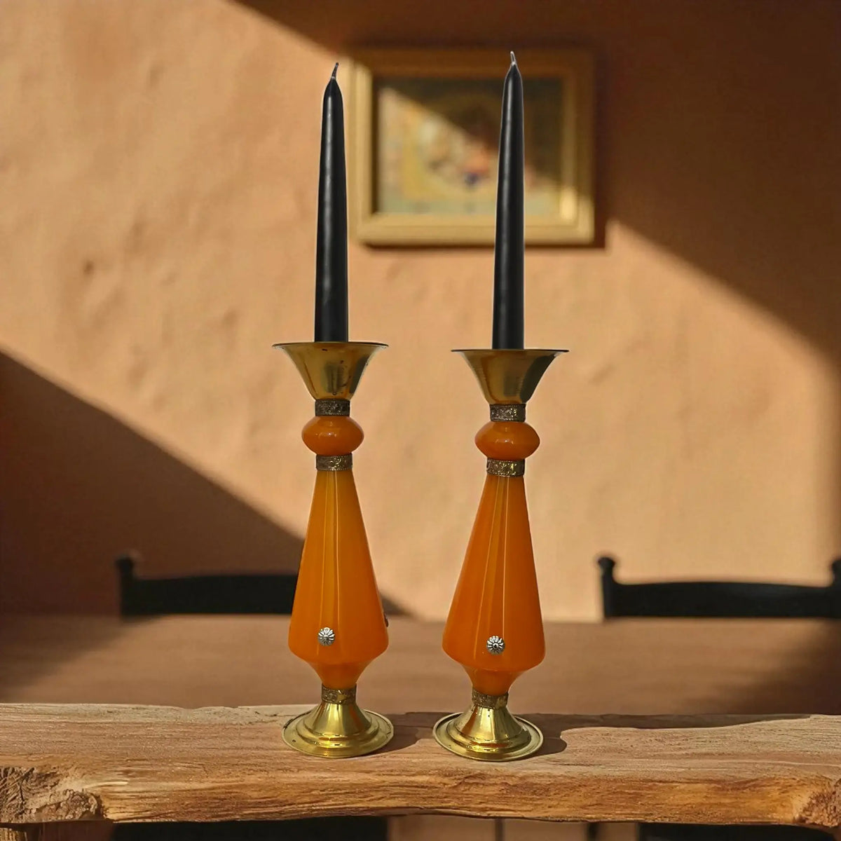 Two Amber resin and brass candlestick with flared top and sunburst medallion, 22 cm tall vintage decorative candle holder on a wooden surface, blurred background