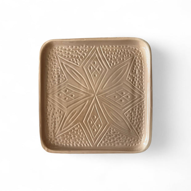Square ceramic plate with geometric pattern on a white background