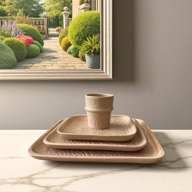 Set of terracotta planters on a marble surface with a garden scene reflected in a mirror.