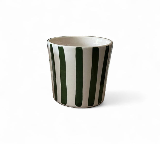 Ceramic cup with black and white striped design on a white background