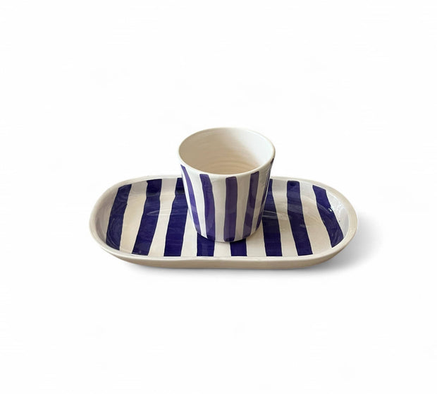 Ceramic cup and tray with blue and white stripes on a white background
