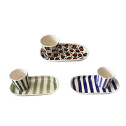 Set of ceramic dishes with animal print and striped patterns on a white background