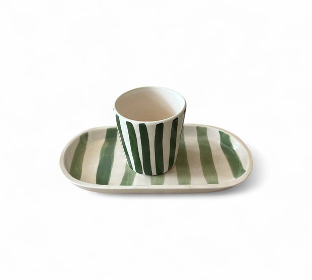 Ceramic cup and saucer with green stripes on a white background