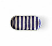 Rectangular ceramic tray with blue and white vertical stripes on a white background