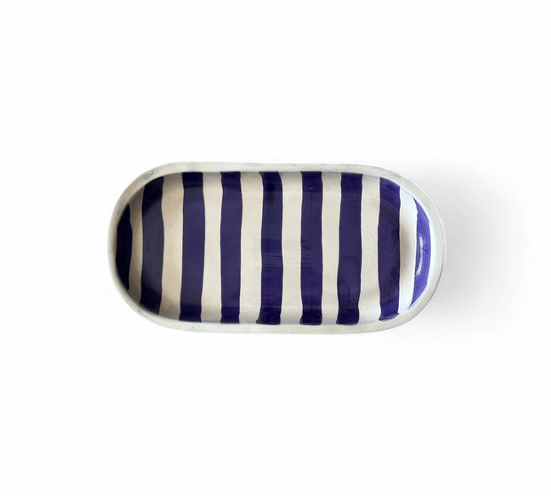 Rectangular ceramic tray with blue and white vertical stripes on a white background