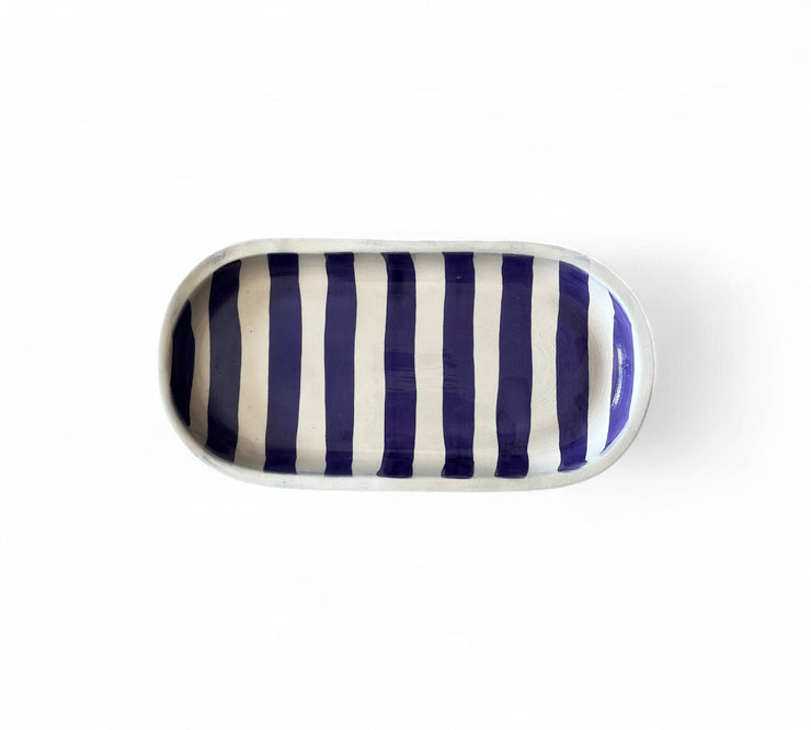 Rectangular ceramic tray with blue and white vertical stripes on a white background