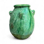 Green ceramic jar with a textured surface on a white background