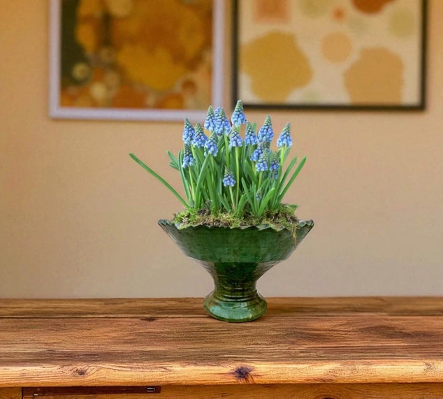 Decorative vase with blue flowers on a wooden surface with a neutral background