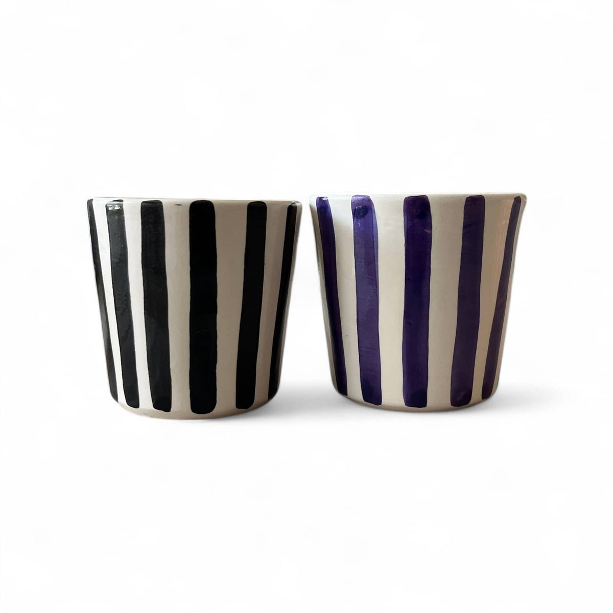 Two ceramic cups with black and purple stripes on a white background