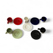 Set of ceramic cups and saucers in various colors on a white background