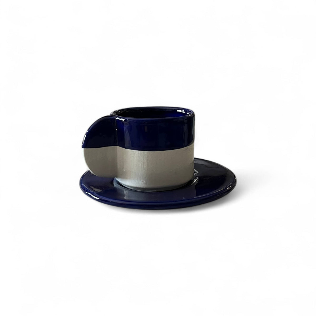 Navy blue and white ceramic cup and saucer on a white background