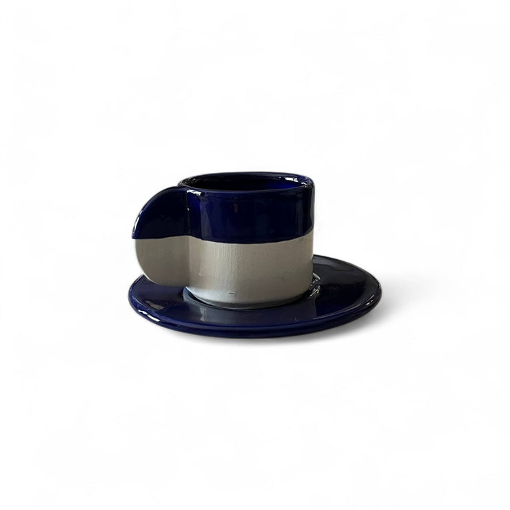 Navy blue and white ceramic cup and saucer on a white background
