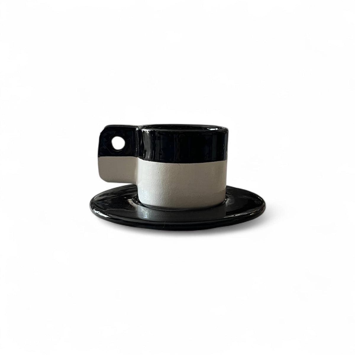 Black and white ceramic cup and saucer on a white background