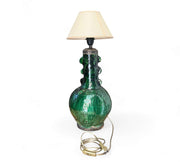 Green ceramic table lamp with a beige lampshade on a white background