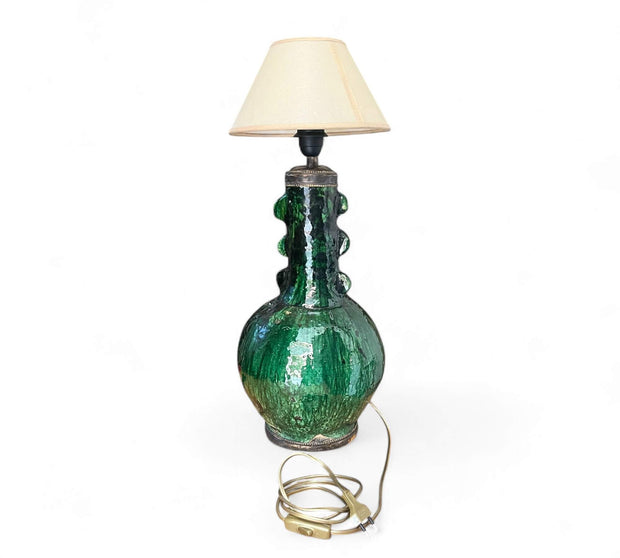 Green ceramic table lamp with a beige lampshade on a white background