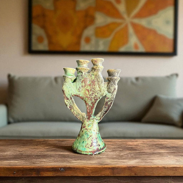 Vintage-style green candle holder on a wooden surface with a blurred background
