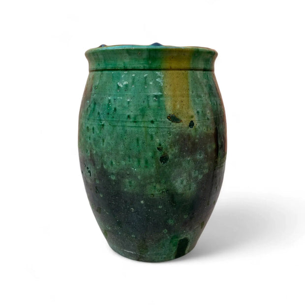 Green ceramic vase with textured surface on a white background