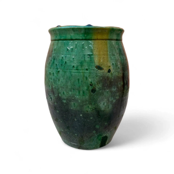 Green ceramic vase with textured surface on a white background