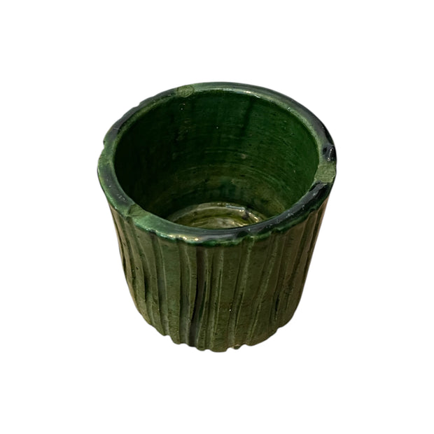 Green ceramic planter with ribbed texture on a white background