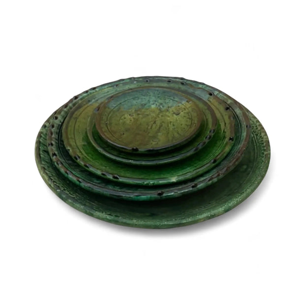 Set of three green ceramic plates stacked on a white background