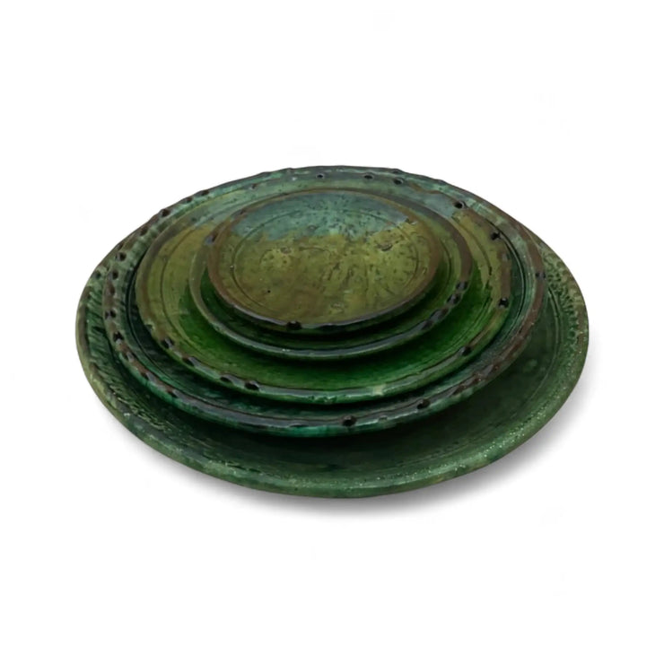 Set of three green ceramic plates stacked on a white background