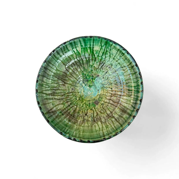 Green ceramic plate with a unique pattern on a white background