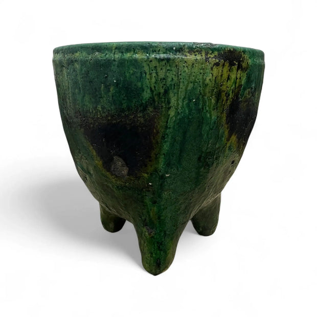 Green ceramic pot with a textured surface on a white background
