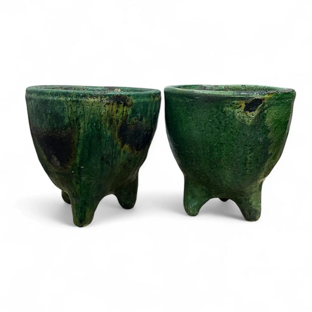 Two green ceramic pots on a white background