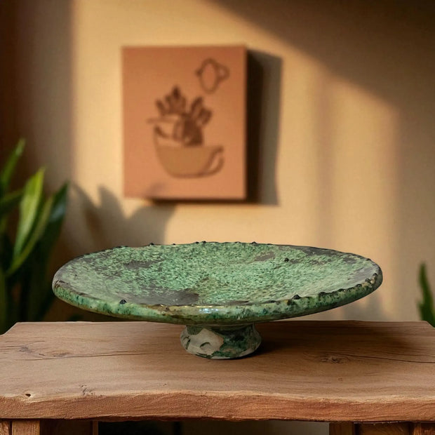 Green ceramic plate on a wooden surface with a blurred background