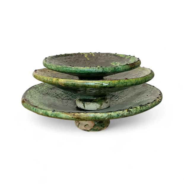 Stack of green ceramic plates on a white background