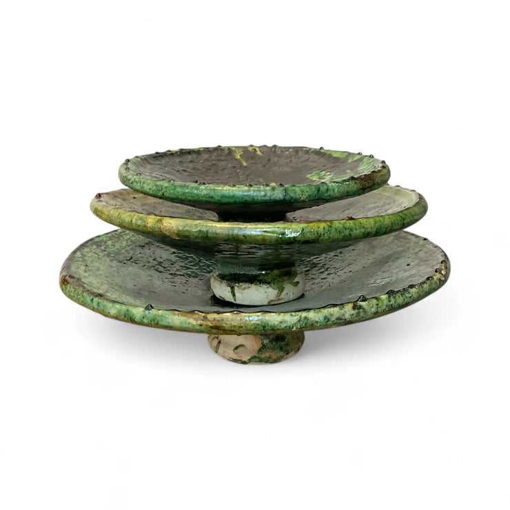 Stack of green ceramic plates on a white background