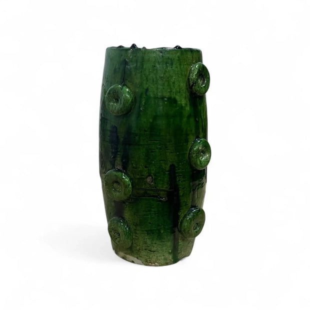 Green ceramic vase with textured surface on a white background