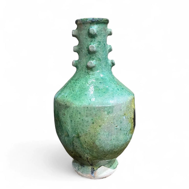 Green ceramic vase with textured surface on a white background