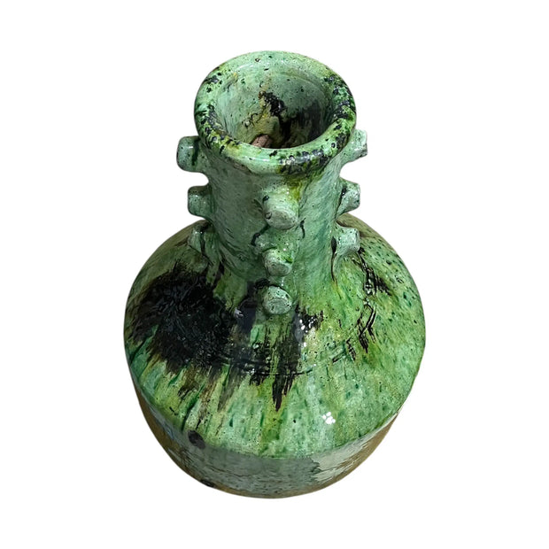 Green ceramic vase with textured surface on a white background