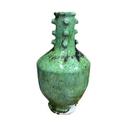 Green ceramic vase with textured surface on a white background