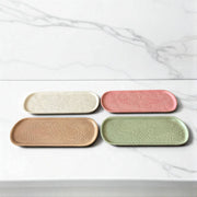 Four ceramic trays in different colors on a marble surface