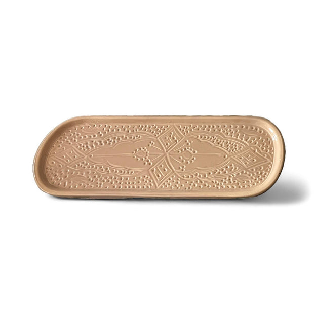 Decorative beige ceramic tray with intricate patterns on a white background