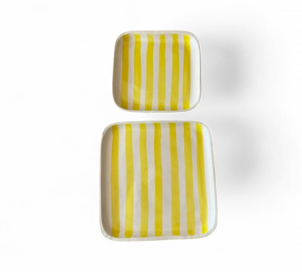 Two rectangular ceramic plates with yellow and white vertical stripes on a white background