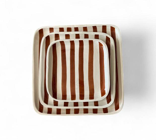 Set of three square ceramic trays with brown and white striped pattern on a white background