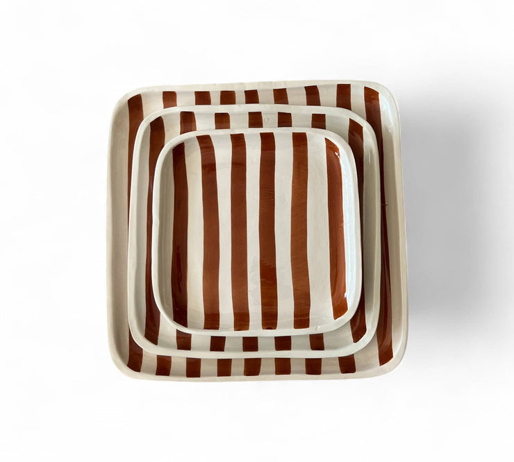 Set of three square ceramic trays with brown and white striped pattern on a white background